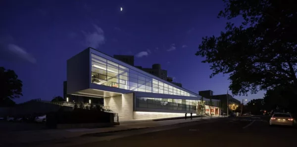 A night view of the Queens Hospital Emergency Medical Station, designed to blend seamlessly into the residential neighborhood fabric