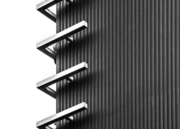 Black and white close-up of exterior structural bars forming abstract patterns.