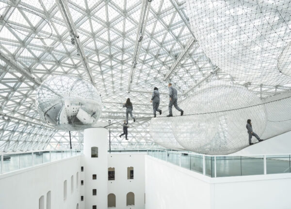 Tomás Saraceno’s In Orbit installation hanging 25 meters above K21 atrium.