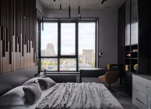 Bedroom workspace in front of a large window overlooking the city in a Moscow loft apartment.