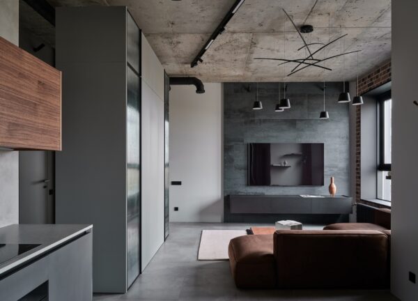 Living room with wall-mounted TV and exposed raw ceiling in a loft-style apartment.