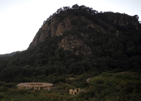 Distant aerial view of Casa 720 surrounded by forest overlooking the lake.