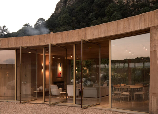 Close-up exterior shot of Casa 720 through glass windows and doors, blurring inside and out.