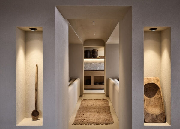 Decorated hallway at Domes Noruz Mykonos featuring organic textures and ambient lighting.