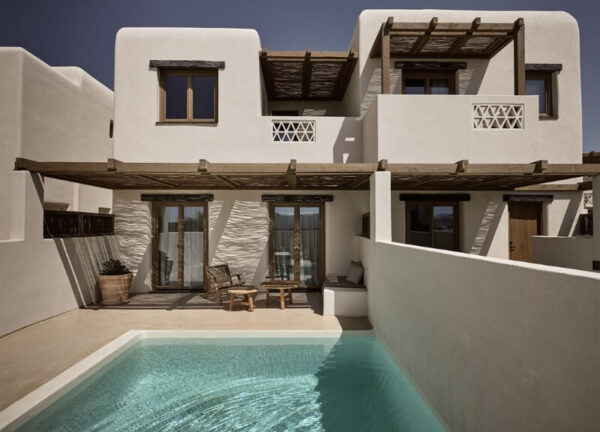 "Backyard pool area at Domes Noruz Mykonos, framed by Cycladic arches and landscaping.