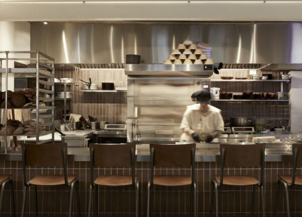 Interior of ERGON Bakehouse showing bakery production area integrated with guest seating.