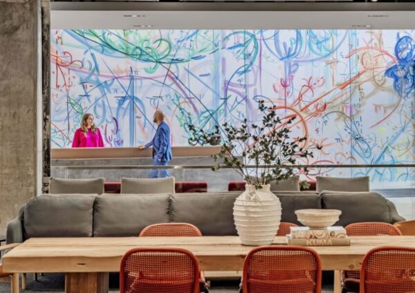 Interior lobby with lounge seating, collaborative tables, and natural light within a lab and office campus, winner of interior architecture design awards.